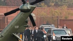 Staf Senior Gedung Putih sedang berdiskusi, sementara Presiden Donald Trump duduk di dalam mobil setelah batal terbang ke Zona Bebas Militer yang memisahkan Korea Selatan dan Korea Utara, 8 November 2017. 