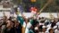 A supporter of Aam Aadmi (Common Man) Party (AAP) cheers after its leader Arvind Kejriwal took an oath as the new chief minister of Delhi during a swearing-in ceremony at Ramlila ground in New Delhi, Dec. 28, 2013. 