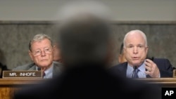 Senаtor John McCain (R) asks a question of defense secretary nominee Chuck Hagel (C) on Capitol Hill in Washington January 31, 2013, as Senator James Inhofe (L) looks on.