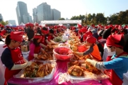 FILE - Participants make kimchi, a staple Korean side dish made of fermented vegetables, for a Guinness World Record for the largest number of people making kimchi at one place during the Seoul Kimchi Festival at Seoul Plaza in Seoul, Nov. 4, 2018.