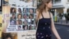 (FILE) A woman makes her way past images of those taken hostage or killed during the deadly October 7 attack in Tel Aviv, Israel September 16, 2024.