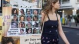 (FILE) A woman makes her way past images of those taken hostage or killed during the deadly October 7 attack in Tel Aviv, Israel September 16, 2024.