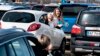 Jóvenes reaccionan durante un servicio de Pascuas en autos en un estacionamiento del Aeropuerto Aalborg, en Dinamarca, el 12 de abril de 2020. 