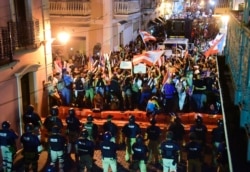 FILE - Demonstrators protest against governor Ricardo Rossello, in San Juan, Puerto Rico, July 19, 2019.