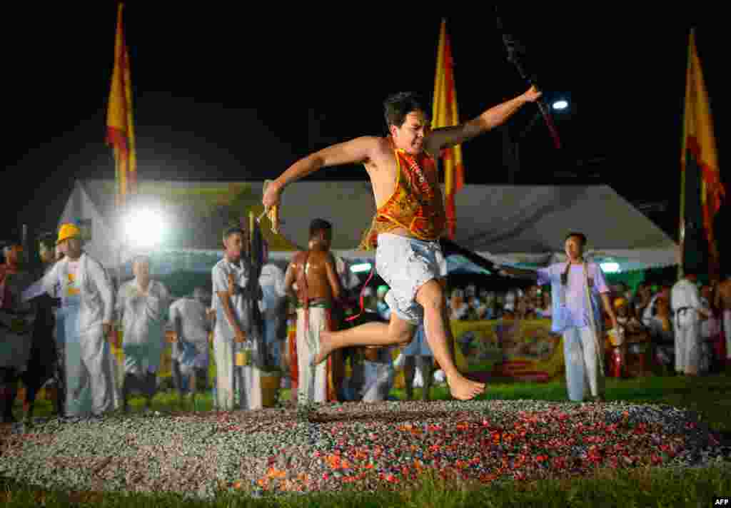 A devotee at a Chinese shrine walks on embers during the yearly Vegetarian Festival in Phuket, Thailand.