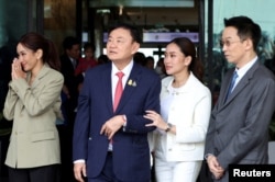 Mantan perdana menteri Thailand Thaksin Shinawatra didampingi putranya, A Panthongtae Shinawatra dan kedua putrinya, Paetongtarn Shinawatra dan Pintongtha Kunakornwong, tiba di Bandara Don Mueang, Bangkok, Thailand, 22 Agustus 2023. (Foto: Athit Perawongmetha/Reuters)