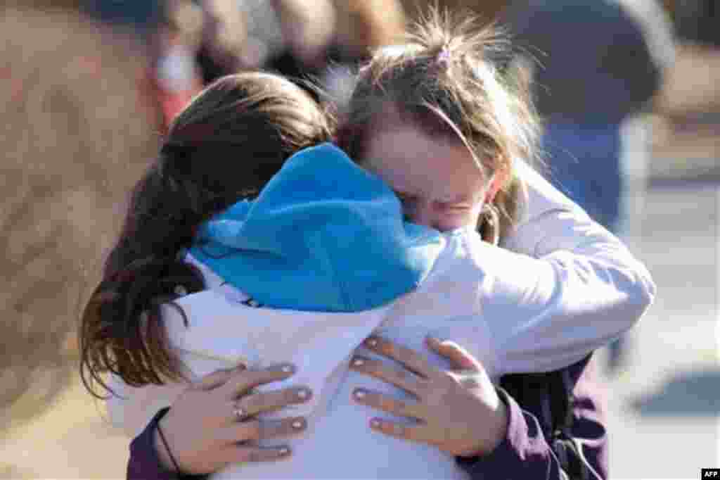 An unidentified student is comforted outside Walpole Elementary School where a 14 year old male student shot himself in front of many classmates in the school's cafeteria in Walpole, NH Friday, Feb. 10, 2012. Police are investigating the shooting, which