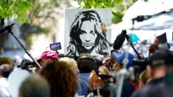FILE - A portrait of Britney Spears looms over supporters and media members outside a court hearing concerning the pop singer's conservatorship at the Stanley Mosk Courthouse, in Los Angeles, June 23, 2021.