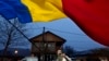 A man waves the Romanian flag outside a closed voting station after Romania's Constitutional Court annulled the first round of presidential elections, in Mogosoaia on Dec. 8, 2024. The EU said on Dec. 17 it was investigating video-sharing platform TikTok regarding the election.