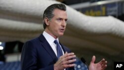 FILE — Gov. Gavin Newsom discusses the acquisition of the Sleep Train Arena for use as a field hospital, after touring the facility, in Sacramento, California, April 6, 2020.