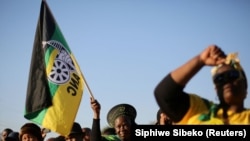 FILE - Supporters of the African National Congress hold the party flag during ANC campaign in Atteridgeville township, South Africa, July 5, 2016.