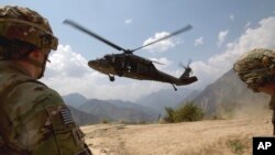 FILE -Soldiers with the U.S. Army's 2nd Battalion 27th Infantry Regiment based in Hawaii, pull security as a Blackhawk helicopter lands during an assessment mission.