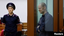 FILE - Wall Street Journal reporter Evan Gershkovich, who stands trial on espionage charges, reacts inside an enclosure for defendants before a court hearing in Yekaterinburg, Russia, June 26, 2024.