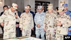 FILE - A handout picture released by the Egyptian Presidency Feb. 25, 2018, shows Egyptian President Abdel Fattah el-Sissi (R), dressed in uniform, during a visit to a regional military headquarters at an undisclosed location. 