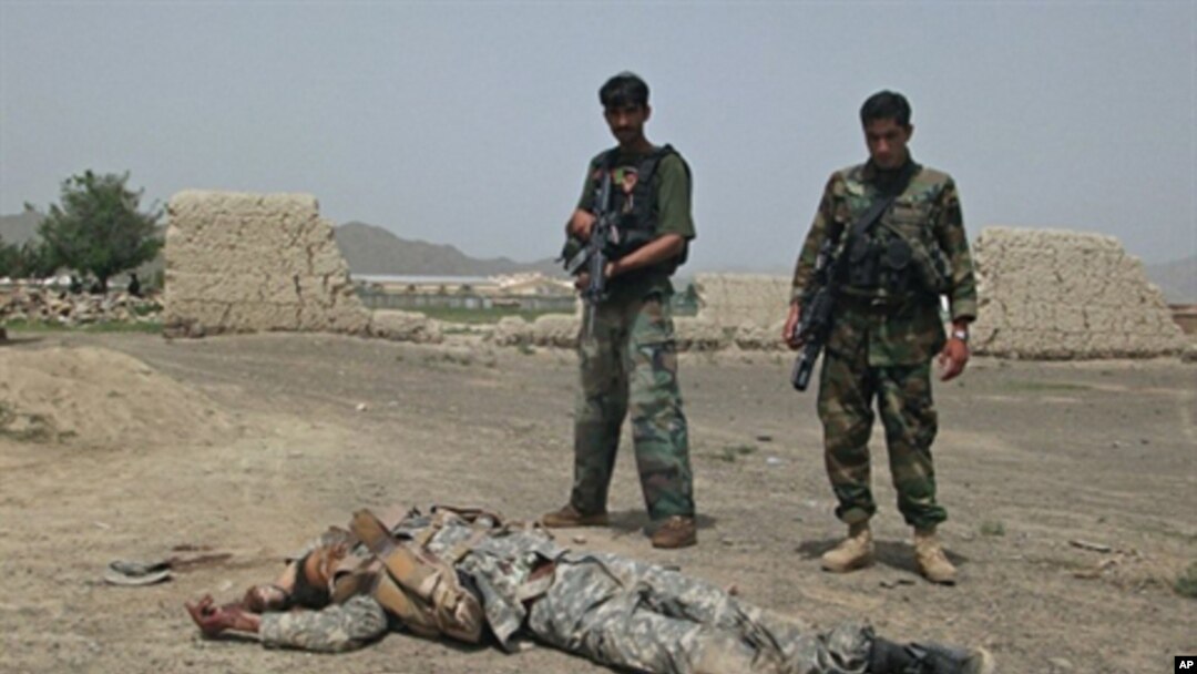 Afghan National Army (ANA) soldiers stand guard near the body of a suicide attacker near US military camp Salerno on the outskirts of Khost city, 28 Aug 2010