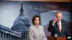 FILE - Democratic House Speaker Nancy Pelosi looks on as Senate Democratic Minority Leader Chuck Schumer speaks during a news conference, on Capitol Hill, in Washington, Feb.11, 2020.