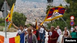 FILE - Buddhist monk Thubten Wangchen (3rd R) and participants walk with Tibetan flags and images of Mahatma Gandhi during their march for "peace and non-violence" from Plaza d'Espanya [Spain Circus] to the Montjuich castle in Barcelona, Oct. 2, 2010.