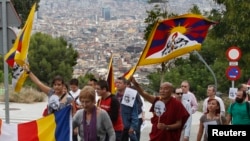 Tu sĩ Phật giáo Thubten Wangchen và những người tham gia cuộc tuần hành 'Vì Hòa bình và Bất bạo động' ở Barcelona, Tây Ban Nha, cầm quốc kỳ Tây Tạng và hình nhà lãnh đạo tinh thần Ấn Độ Mahatma Gandhi, 2/10/2010.