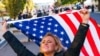 Kelly Janowiak of Chicago, prays with a conservative Christian Evangelical group while holding a American flag, Nov. 2, 2020, in Washington.