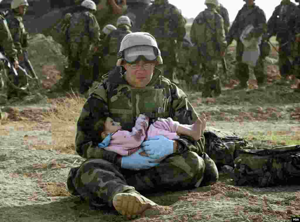 Birinci Dəniz Piyadaları Diviziyasında xidmət edən ABŞ Donanma hospital korpusmeni Richard Barnett mərkəzi İraqda uşağı qucağında tutub. (29 mart, 2003).&nbsp; Döyüş zamanı uşaq ailəsindən ayrı düşmüşdü.&nbsp; Foto: Damir Sagolj via Business Insider.