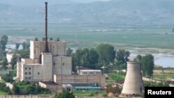 A North Korean nuclear plant is seen before demolishing a cooling tower (R) in Yongbyon, in this photo taken June 27, 2008 and released by Kyodo.