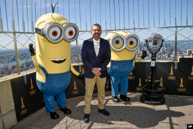 Actor Steve Carell and two Minion characters pose on the 86th floor observatory deck at the Empire State Building to celebrate the upcoming film "Minions: The Rise of Gru" on Tuesday, June 28, 2022, in New York. (Photo by Evan Agostini/Invision/AP)