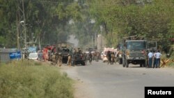 Tentara Pakistan berkumpul di dekat pangkalan udara di dekat Peshawar, Pakistan Baratlaut yang diserang oleh kelompok Taliban hari Jumat (18/9) pagi.