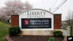 A sign marks the entrance to Liberty University, March 24 , 2020, in Lynchburg, Virginia. University President Jerry Falwell Jr. invited students back to campus this week, despite the fast-growing coronavirus pandemic.