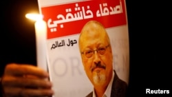 Seorang demonstran membawa poster Jamal Khashoggi dalam aksi unjuk rasa di depan Kedutaan Saudi di Istanbul, Turki. 