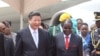 Chinese President Xi Jinping, right, and Zimbabwean President Robert Mugabe hold hands upon his arrival in Harare, Zimbabwe, Tuesday, Dec. 1. 2015.