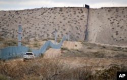 FILE - A U.S. Border Patrol agent drives near the U.S.-Mexico border fence in Sunland Park, New Mexico, Jan. 4, 2016.