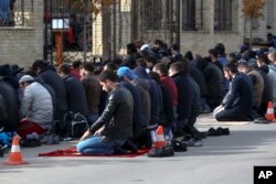 In this photo taken Friday, Nov. 13, 2015, men attend a Friday prayer at the mosque on Kotrova street in Dagestan's regional capital Makhachkala, Russia. An epidemic of recruitment for the Islamic State group has swept through the predominantly Muslim parts of Russia.