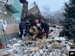 En esta fotografía proporcionada por el Servicio de Emergencia de Ucrania, los rescatistas ayudan a una persona herida después de que una casa que fuera destruida por un ataque con misiles rusos, en Novomoskovsk, cerca de Kryvyi Rih, Ucrania, el lunes 8 de enero de 2024.