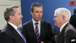British Defense Secretary Liam Fox (L) talks to NATO Secretary General Anders Fogh Rasmussen (C) and U.S. Secretary of Defense Robert Gates during a NATO defense ministers meeting at the Alliance headquarters in Brussels June 8, 2011.