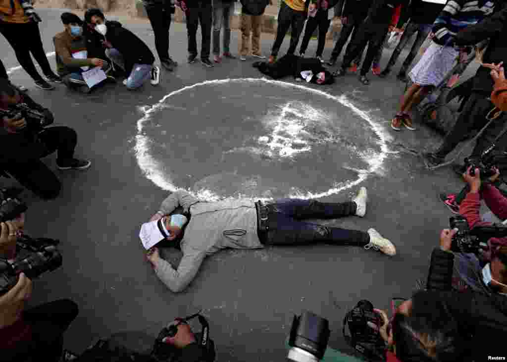 Protesters lie down on the road next to the Nepalese word that means &quot;parliament&quot; during a protest against the dissolution of parliament, in Kathmandu, Nepal.