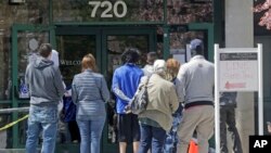 People line up outside the Utah Department of Workforce Services, April 13, 2020, in Salt Lake City. 