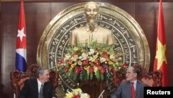 Los presidentes de Cuba, Raul Castro (izquierda) y de la Asamblea Nacional de Vietnam, Nguyen Sinh Hung, conversan bajo una estatua del líder revolucionario Ho Chi Minh, en Hanoi.