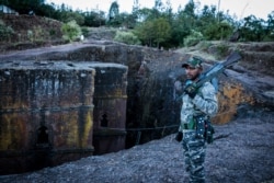 A militia fighter poses at Saint George's Church in Lalibela, Ethiopia, Dec. 7, 2021.