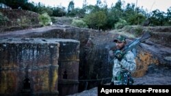 FILE - A militia fighter poses at Saint George's Church in Lalibela, Ethiopia, Dec. 7, 2021.