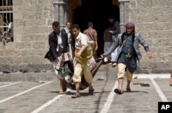 Người bị thương trong vụ đánh bom tự sát được khiêng ra khỏi hiện trường. Mỹ đã rút toàn bộ nhân sự ra khỏi Yemen, 1 ngày sau các tay đánh bom tự sát giết chết ít nhất 137 người tại 2 đền thờ ở thủ đô Sana’a.