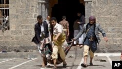 Des secouristes transportant le corps d'une victime à Sanaa (AP)