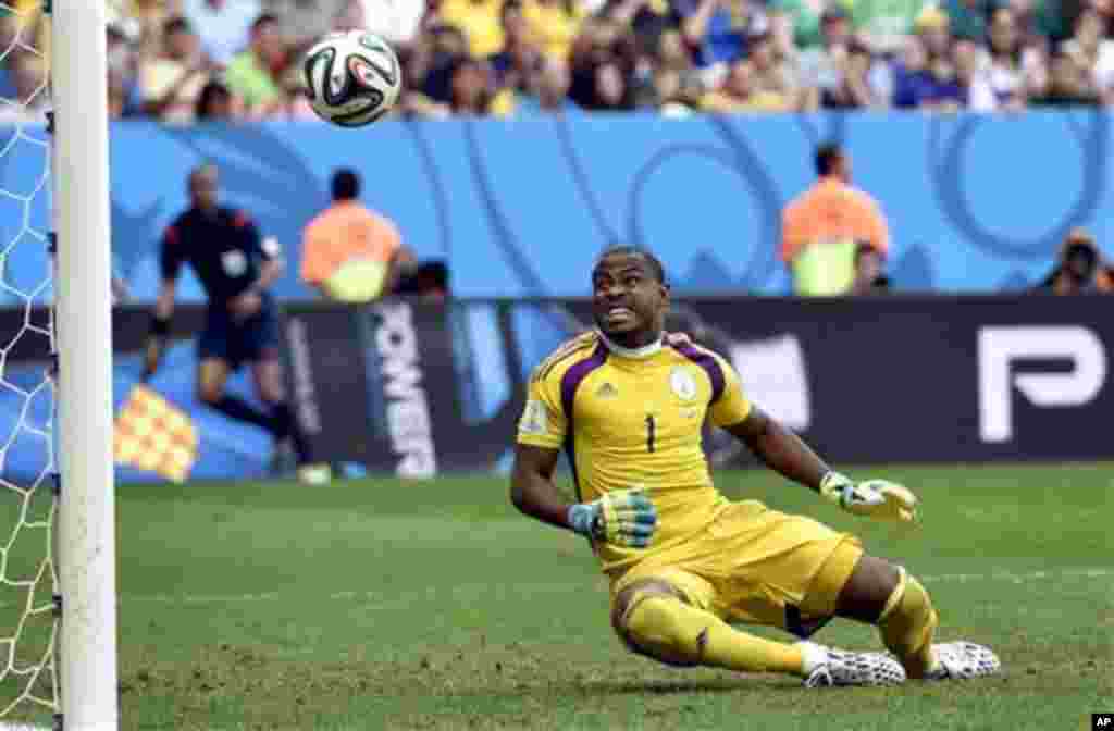 Nigeria's goalkeeper Vincent Enyeama looks as a shFrance's Mathieu Debuchy, right, and Nigeria's Victor Moses fight for the ball during the World Cup round of 16 soccer match between France and Nigeria at the Estadio Nacional in Brasilia, Brazil, Monday, 