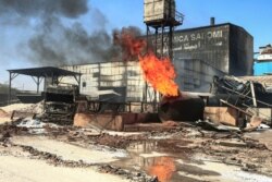 A gas tank burns at the scene of a fire at a tile manufacturing unit in an industrial zone in Sudan's north Khartoum, Dec. 3, 2019.