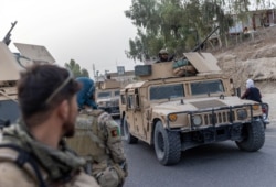 FILE - A convoy of Afghan Special Forces is seen during the rescue mission of a police officer besieged at a checkpoint surrounded by Taliban, in Kandahar province, July 13, 2021.