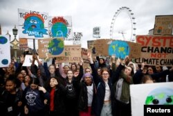 FILE - Demonstrators take part in a protest against climate change, organized by the YouthStrike4Climate movement, in London, March 15, 2019.