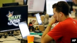 FILE - An employee at DraftKings, a fantasy sports company, is seen working on his laptop at the company's offices in Boston, Massachusetts, Sept. 9, 2015.