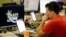 FILE - An employee at DraftKings, a fantasy sports company, is seen working on his laptop at the company's offices in Boston, Massachusetts, Sept. 9, 2015.
