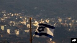 Bendera Israel berkibar di depan desa Majdal Shams, Dataran Tinggi Golan yang dikuasai Israel, 11 Oktober 2018. (Foto: dok)