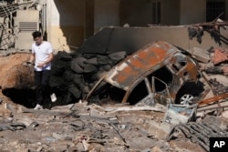 Un hombre camina sobre escombros en el lugar de un ataque aéreo israelí en los suburbios del sur de Beirut, el domingo 29 de septiembre de 2024. (Foto AP/Hassan Ammar)