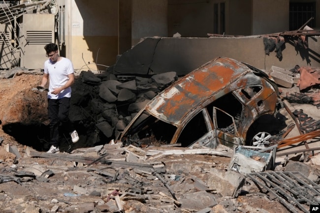 Un hombre camina sobre escombros en el lugar de un ataque aéreo israelí en los suburbios del sur de Beirut, el domingo 29 de septiembre de 2024. (Foto AP/Hassan Ammar)